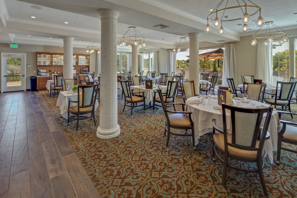 An elegant dining area with neatly arranged tables and chairs, featuring classic interior design elements.