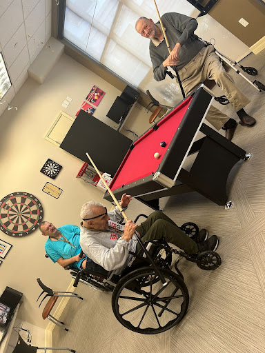 Residents enjoying a game of billiards in their recreational area.