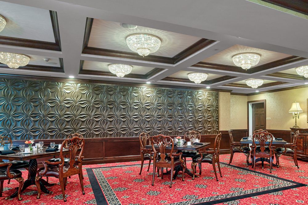 Elegant restaurant interior with intricate wall design and luxurious chandeliers.
