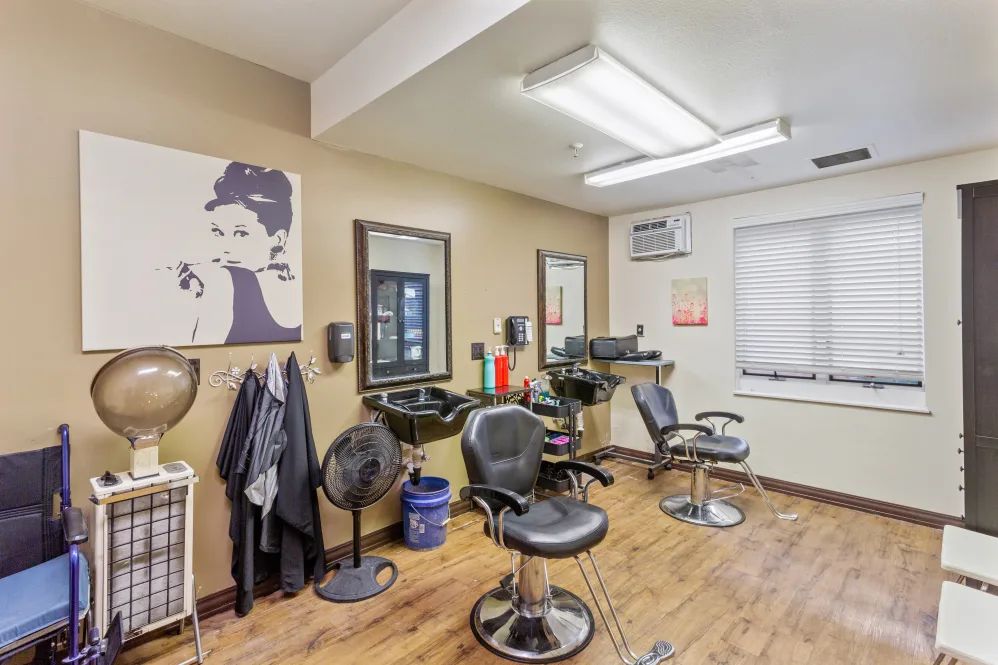 An interior view of a hair salon with styling chairs and equipment set up in front of large mirrors.