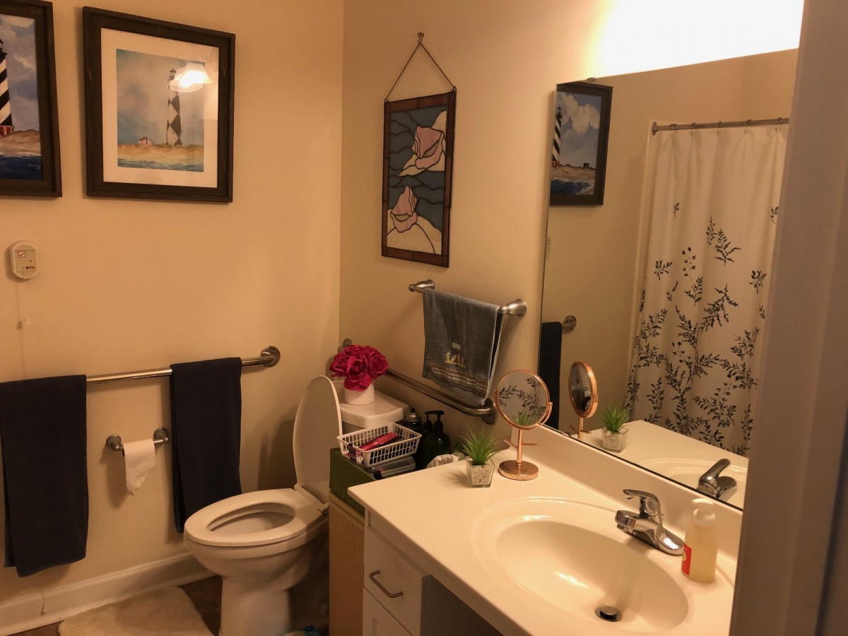 A cozy bathroom with modern amenities and decorative wall art.