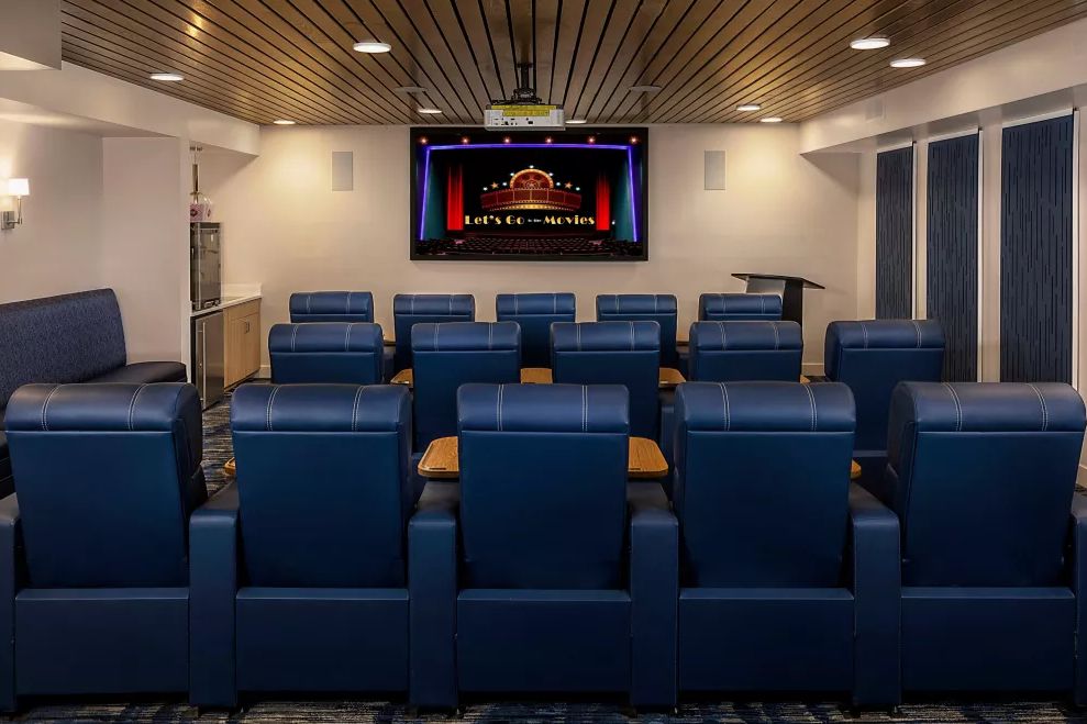 A modern home theater setup with comfortable leather seating and a large projector screen.