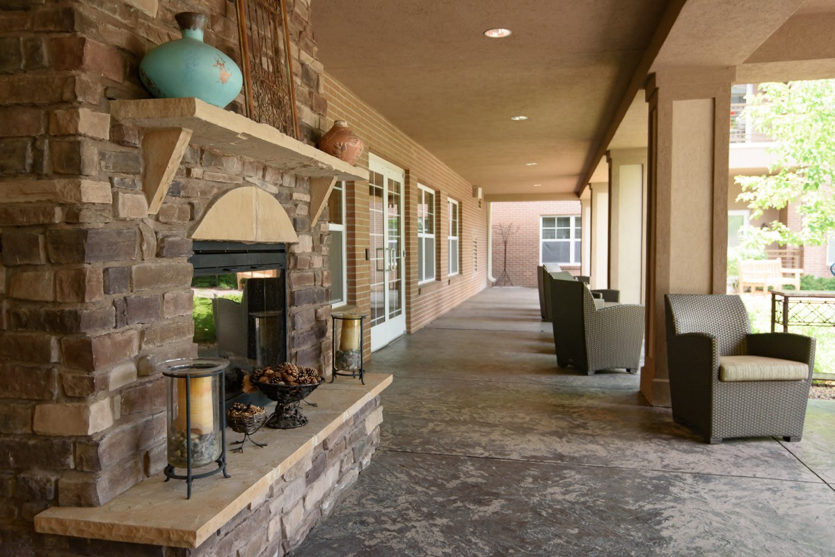A cozy outdoor patio featuring a stone fireplace and comfortable seating.