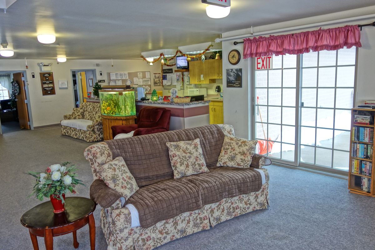 A cozy living room featuring a floral-patterned sofa, fish tank, and sliding patio doors.