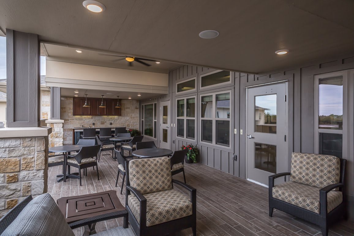A cozy outdoor patio with comfortable seating and a kitchen area.