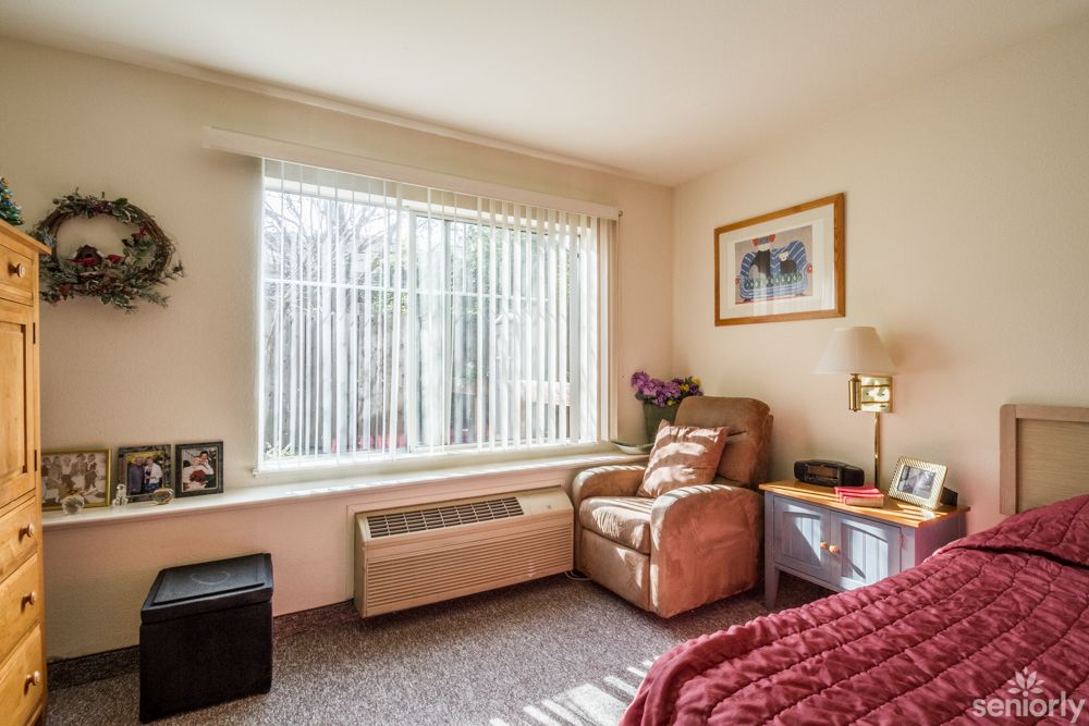 A cozy bedroom corner with a comfortable chair by the window.