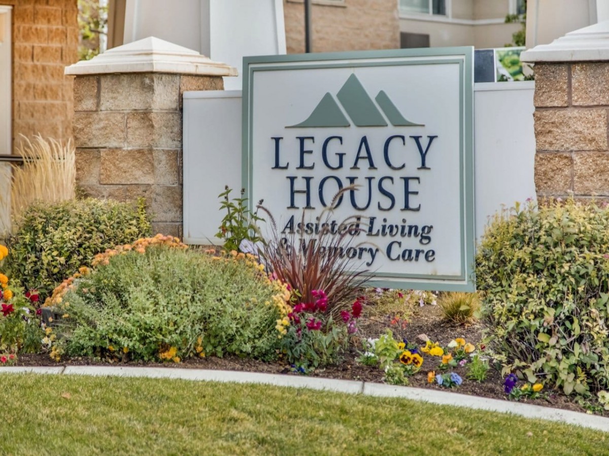 Sign for Legacy House Assisted Living and Memory Care with landscaped garden.