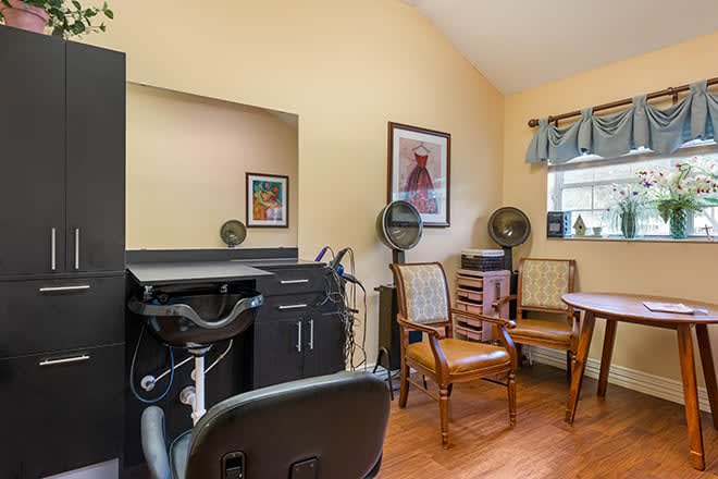 Cozy hair salon interior with a styling station and comfortable seating.