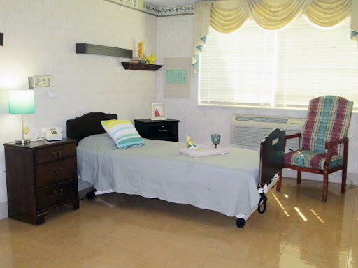 A minimalist hospital room featuring a single bed, a chair, and soft natural lighting from the window.