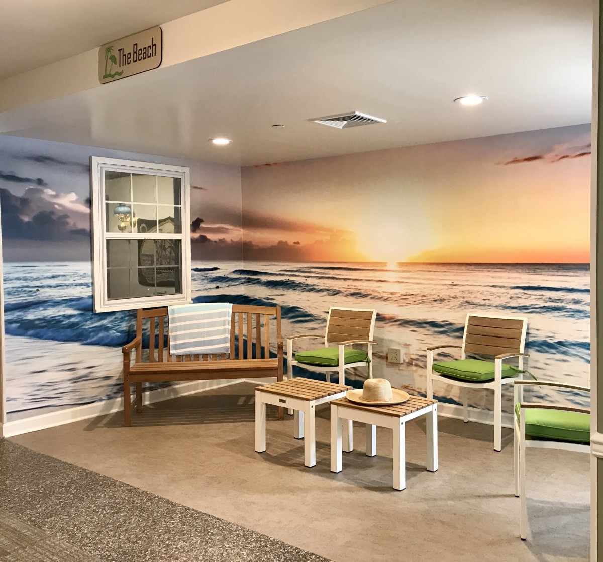 A cozy indoor seating area featuring a vibrant beach sunset mural.