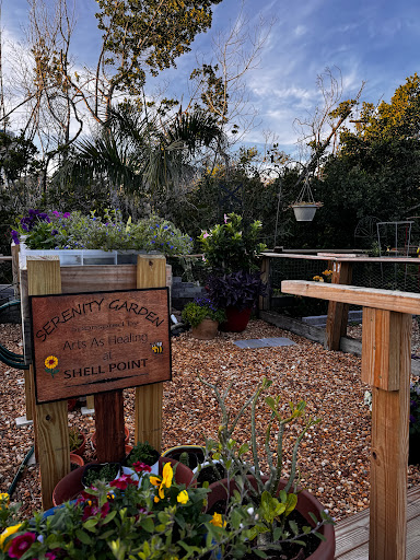 A serene community garden showcasing vibrant plants and a welcoming sign.