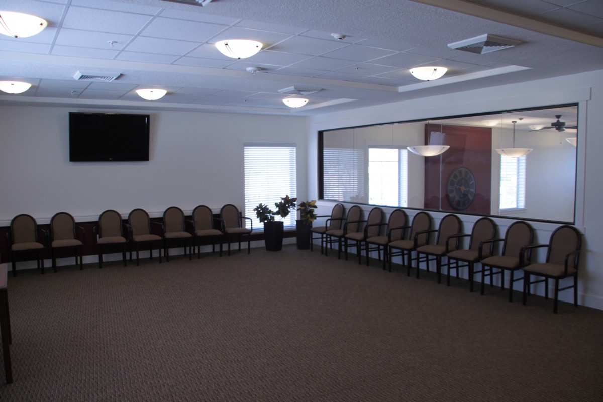 An empty meeting room with chairs arranged around the perimeter.