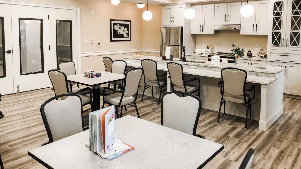 A modern kitchen and dining area with tables, chairs, and stylish lighting.