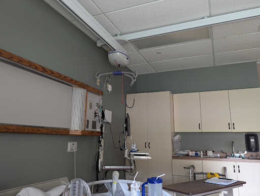 A view of a hospital patient room with medical equipment and a bedside setup.