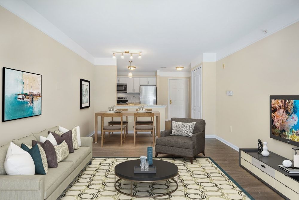 A modern living room with an open floor plan featuring a comfortable seating area and a dining table.