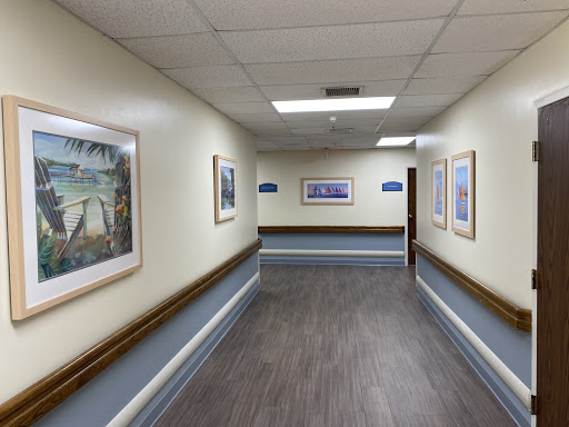 A well-lit hospital corridor adorned with framed artwork.