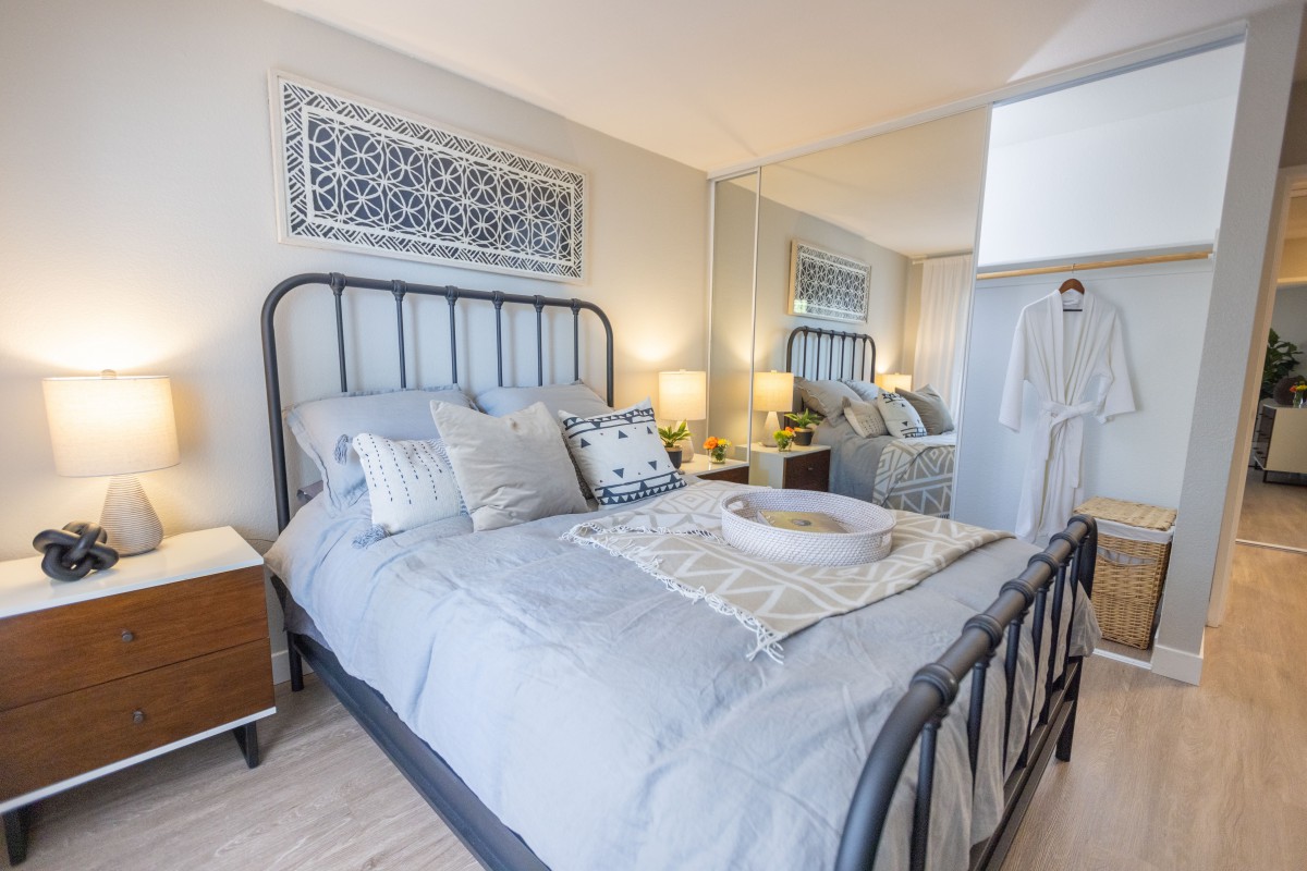A cozy bedroom with elegant decor, featuring a metal frame bed, soft bedding, and stylish nightstands.