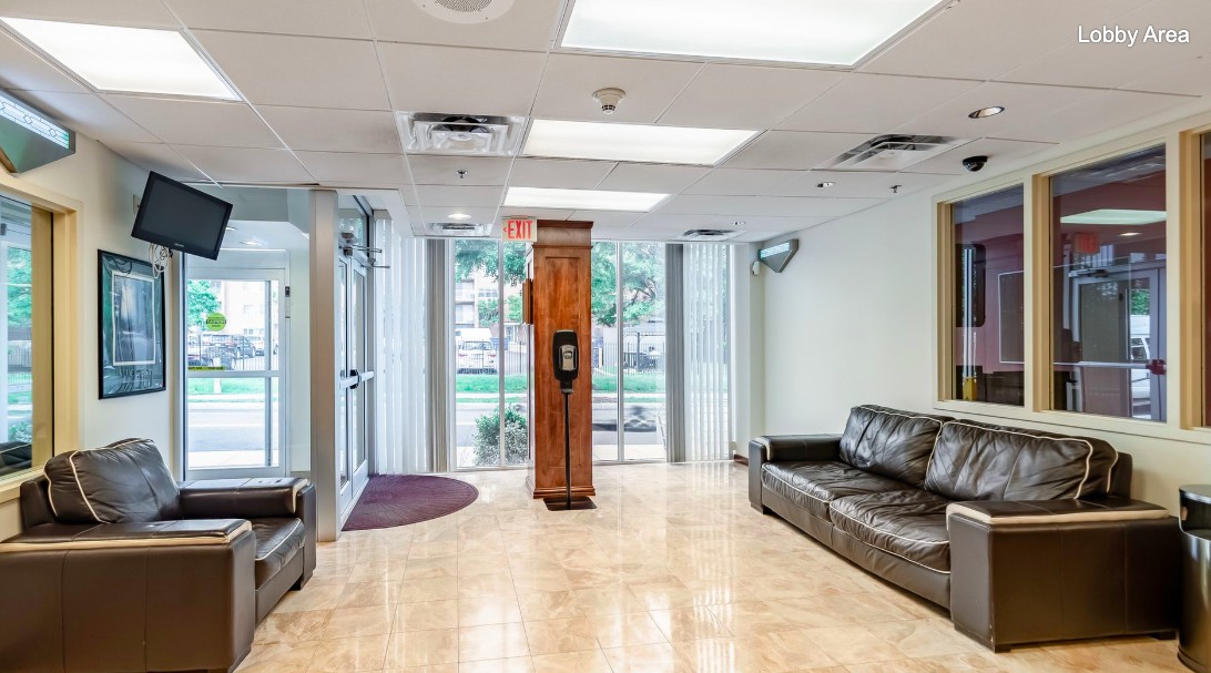 A modern office lobby with leather sofas and glass doors, providing a welcoming waiting area.
