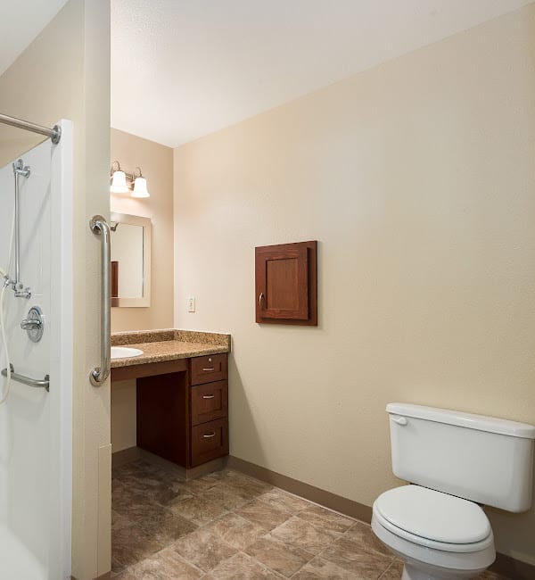 A clean and simple bathroom with a shower, toilet, and sink.