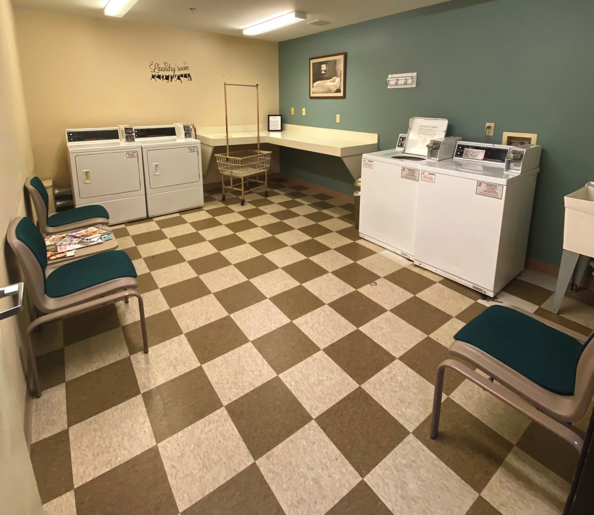A cozy laundry room with washing machines and a waiting area.