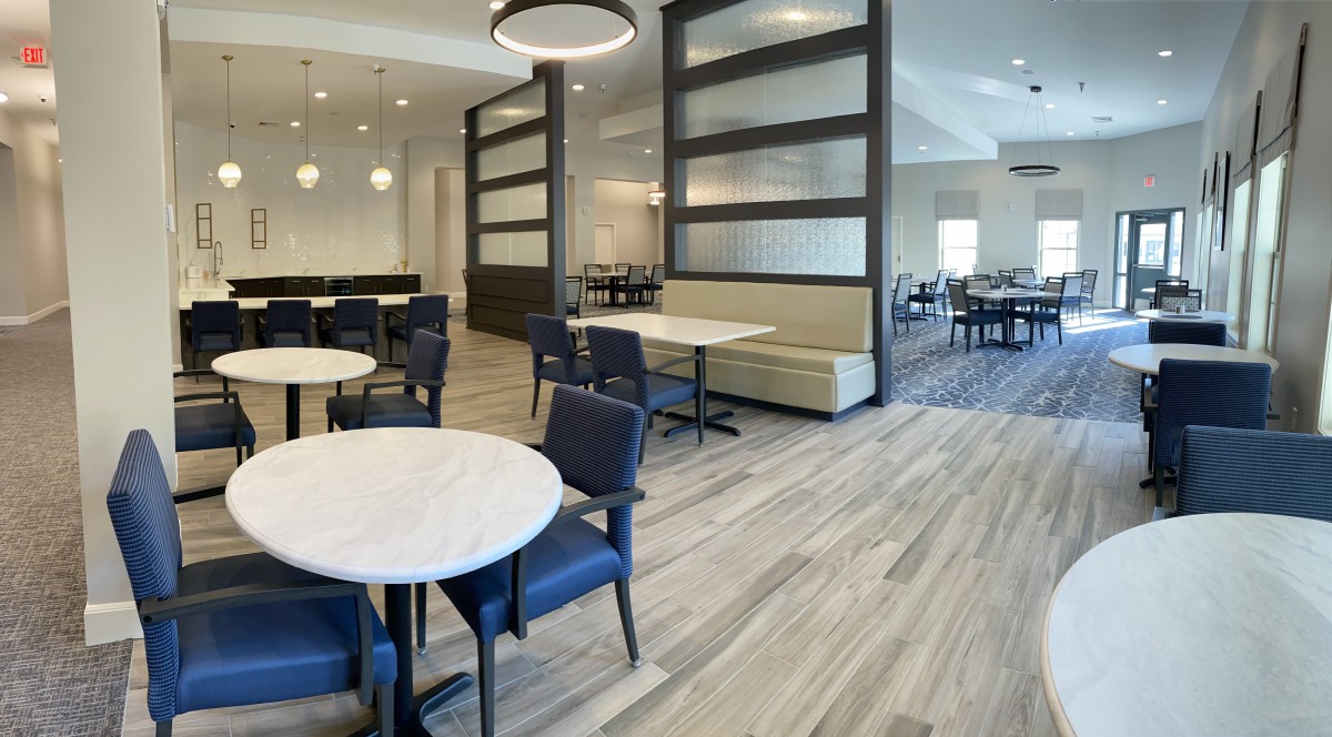 A modern restaurant dining area with elegant tables and chairs, featuring contemporary lighting and stylish flooring.