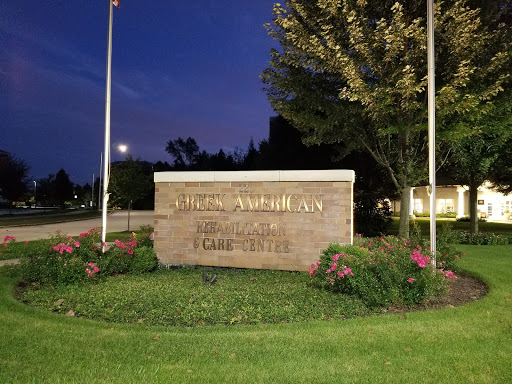 A night view of a welcoming sign at an institution, surrounded by landscaped greenery.