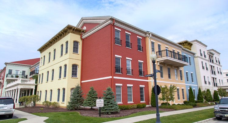 A colorful, multi-story residential building with red and yellow brick facades.
