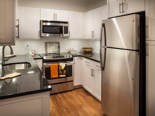 A modern kitchen with stainless steel appliances and white cabinets.
