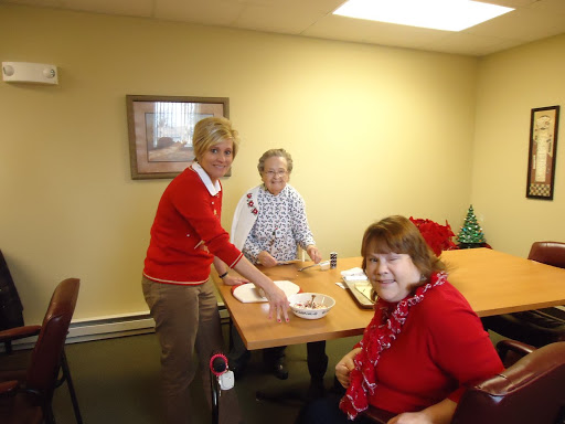 A cheerful gathering of three women engaged in a fun activity at a community center.