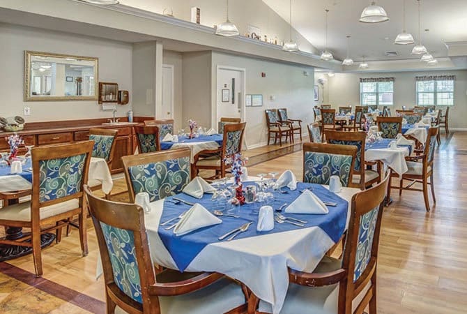 An elegantly set dining room with neatly arranged tables and chairs.