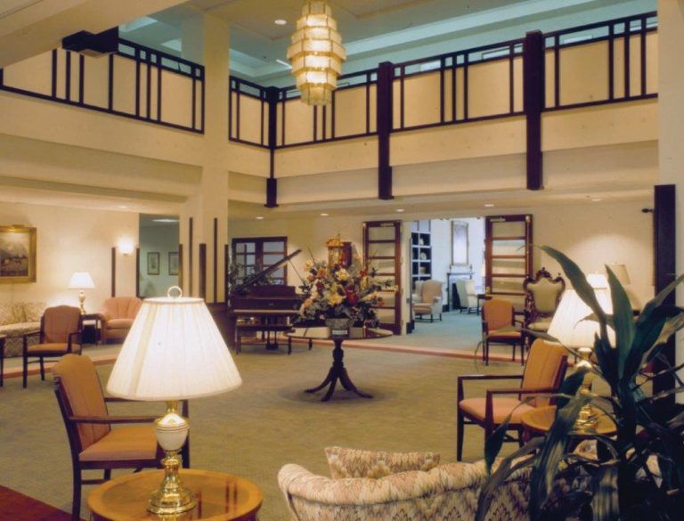 A spacious and elegantly decorated lobby with comfortable seating and a grand chandelier.