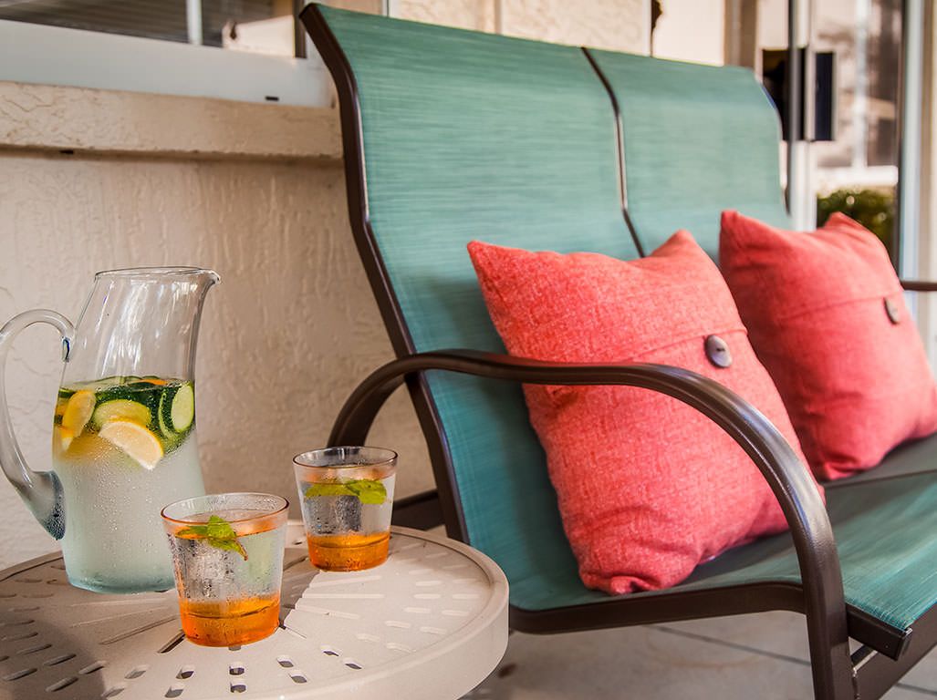 A cozy patio setting with a comfortable chair and refreshing drinks.
