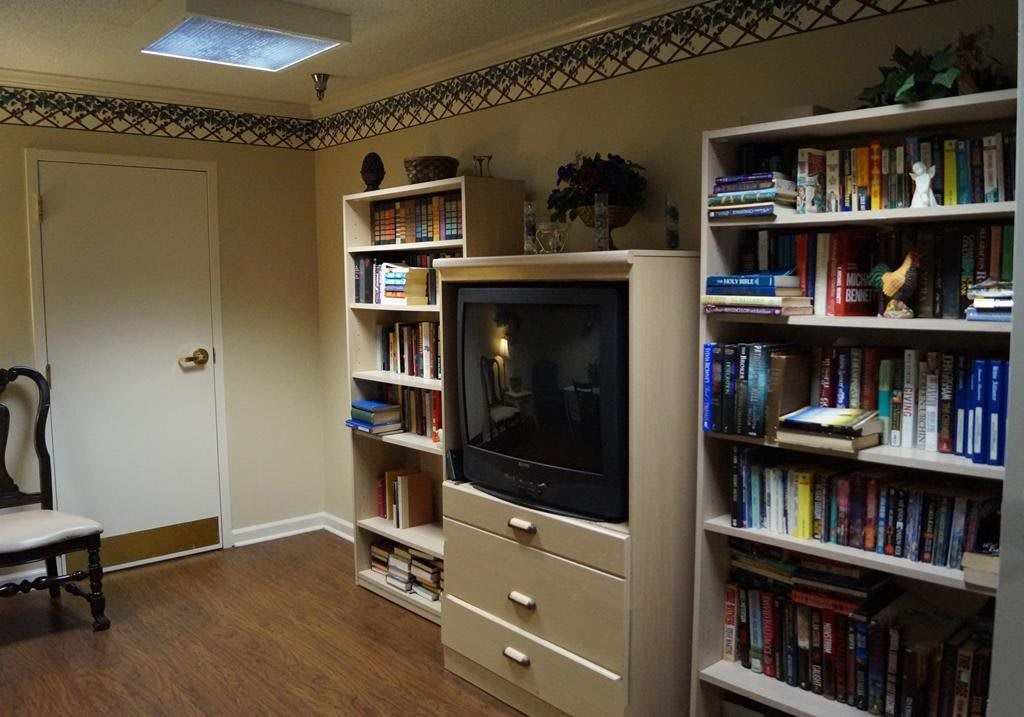 A cozy living room with bookshelves and a television.