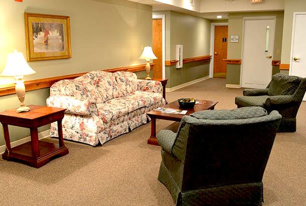 A cozy living room with a floral sofa, chairs, and a coffee table.