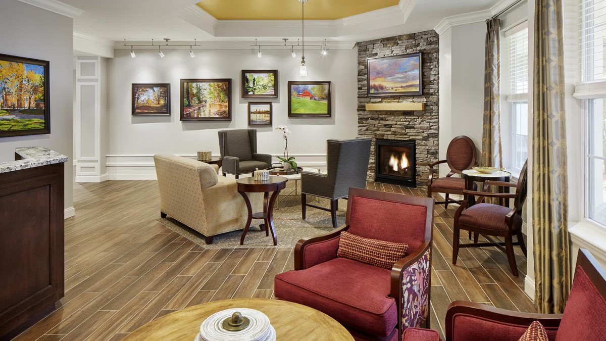 A cozy living room with comfortable seating, a fireplace, and art displayed on the walls.