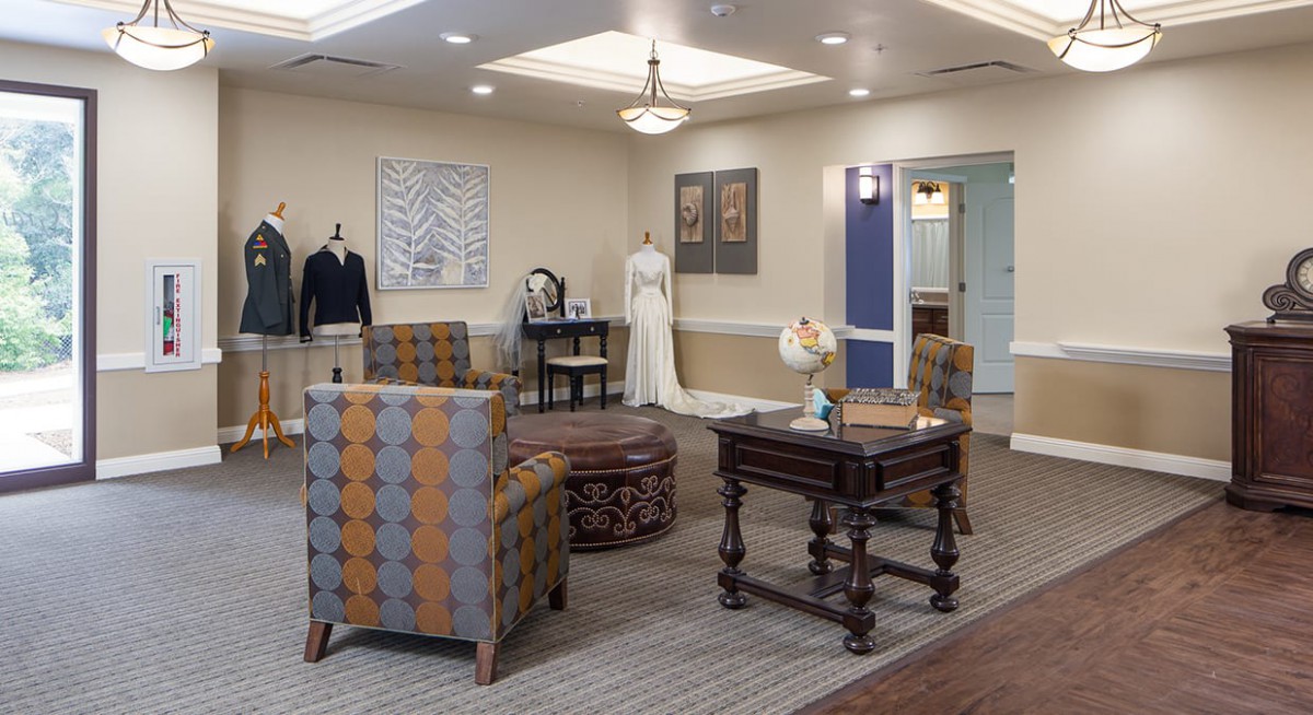 A well-decorated room with furniture and mannequins displaying clothing.
