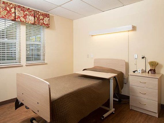 A hospital room with a single bed and medical equipment.
