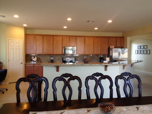 A modern kitchen and dining area featuring wooden cabinets and a stylish table with chairs.