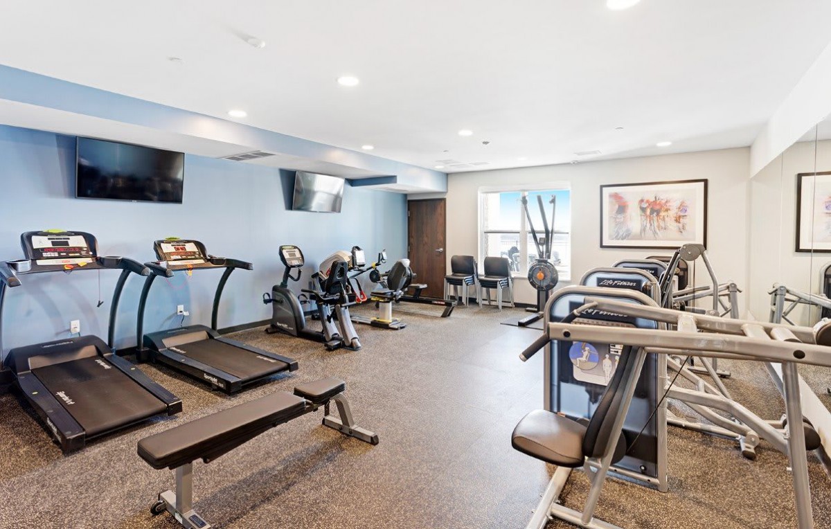 A modern gym equipped with various exercise machines including treadmills and stationary bikes.