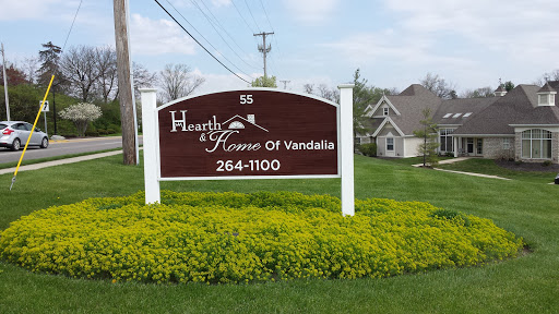Welcome sign for Hearth Home of Vandalia, surrounded by lush greenery.