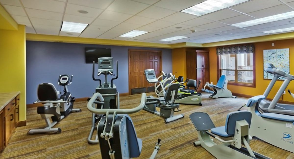 A gym equipped with various exercise machines including stationary bikes and treadmills.