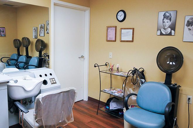 A cozy waiting area in a hair salon with chairs and styling equipment.