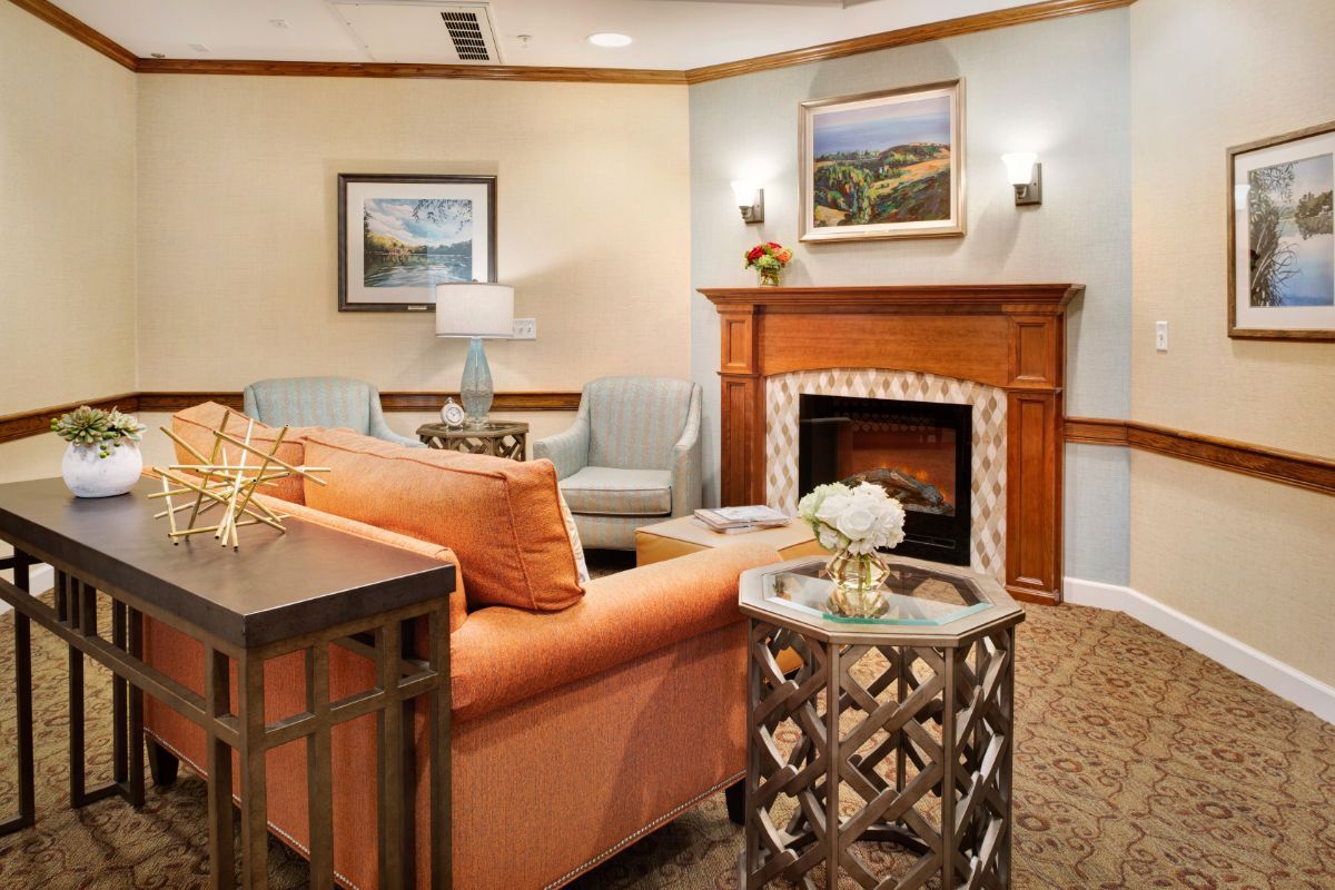 A cozy living room with a warm color palette, featuring a comfortable sofa, decorative fireplace, and stylish artwork.