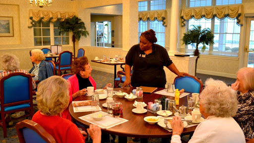 A friendly restaurant scene where a staff member interacts with guests during breakfast.