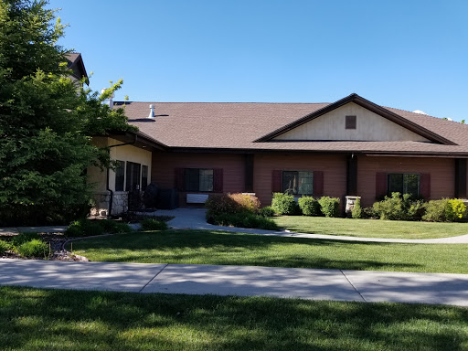 A charming residential home with a well-maintained lawn under a clear blue sky.