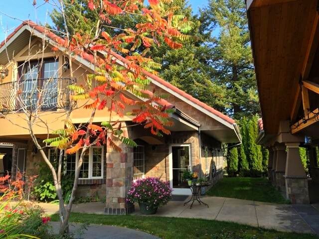 A charming house surrounded by autumn foliage and a well-maintained garden.