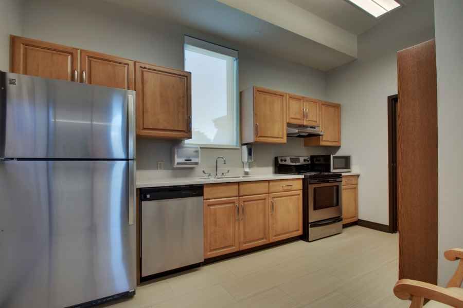 A modern kitchen with stainless steel appliances and wooden cabinets.