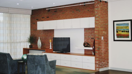 A modern living room featuring a sleek TV unit against a stylish brick wall.
