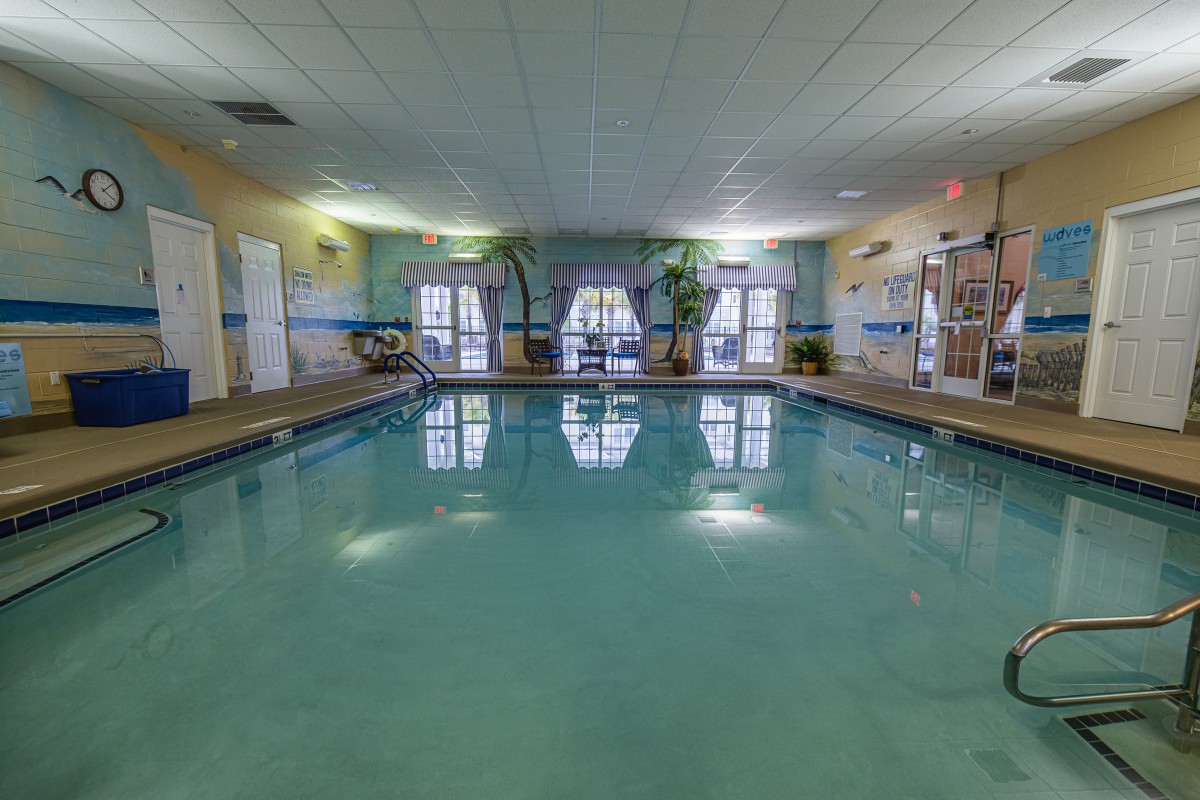 An inviting indoor swimming pool area with natural light and surrounding decor.