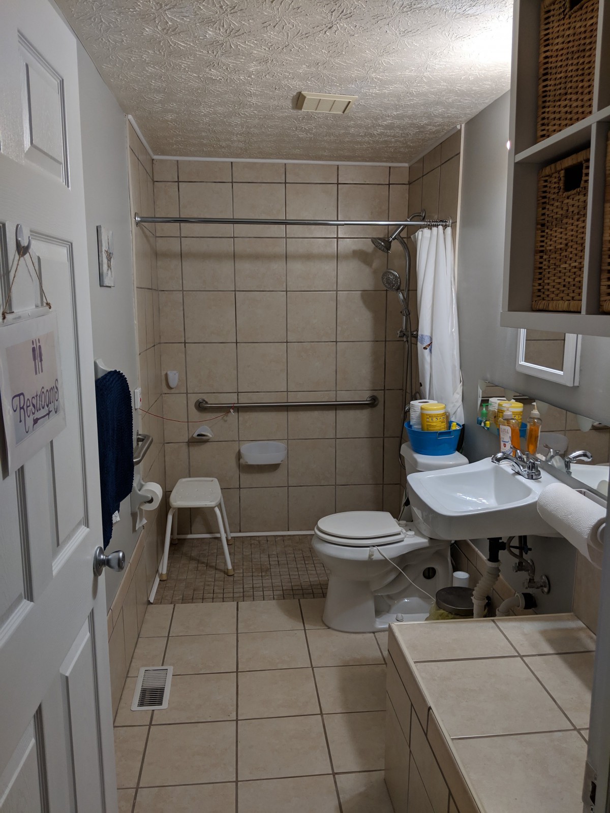 An accessible bathroom with grab bars and a shower chair.